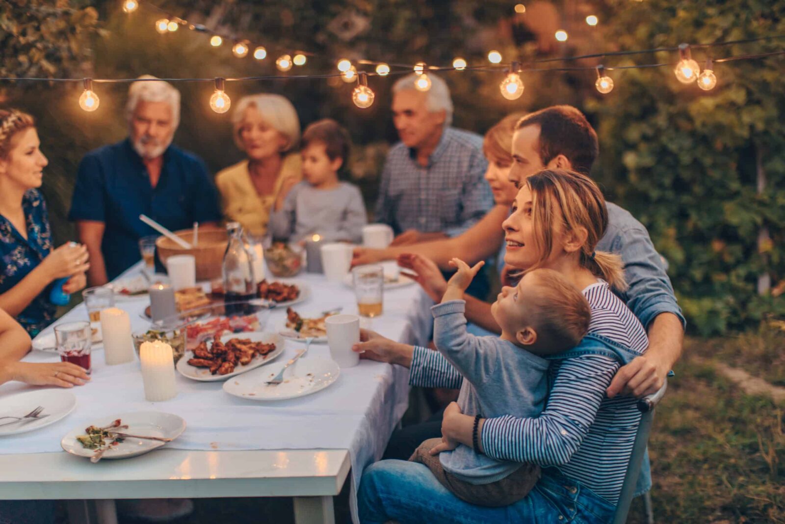 Foto de una familia extensa durante la cena de Acción de Gracias, celebrando juntos las vacaciones en el patio trasero