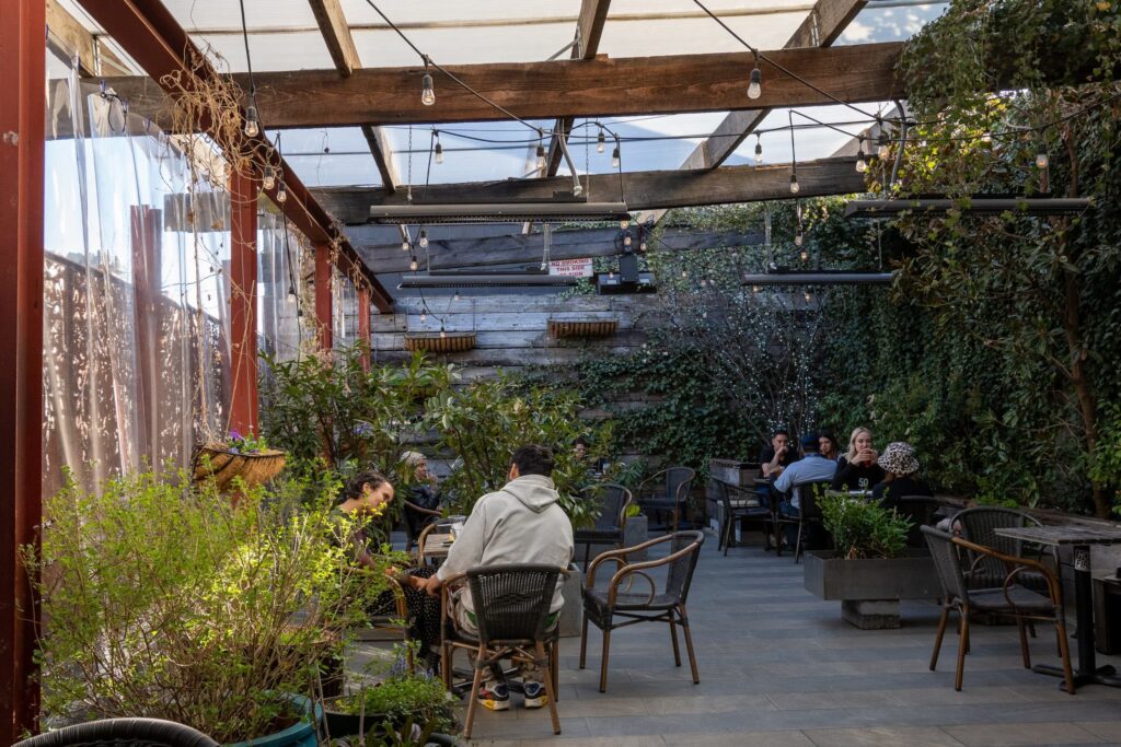 Exuberante patio al aire libre con personas y calefacción para exteriores