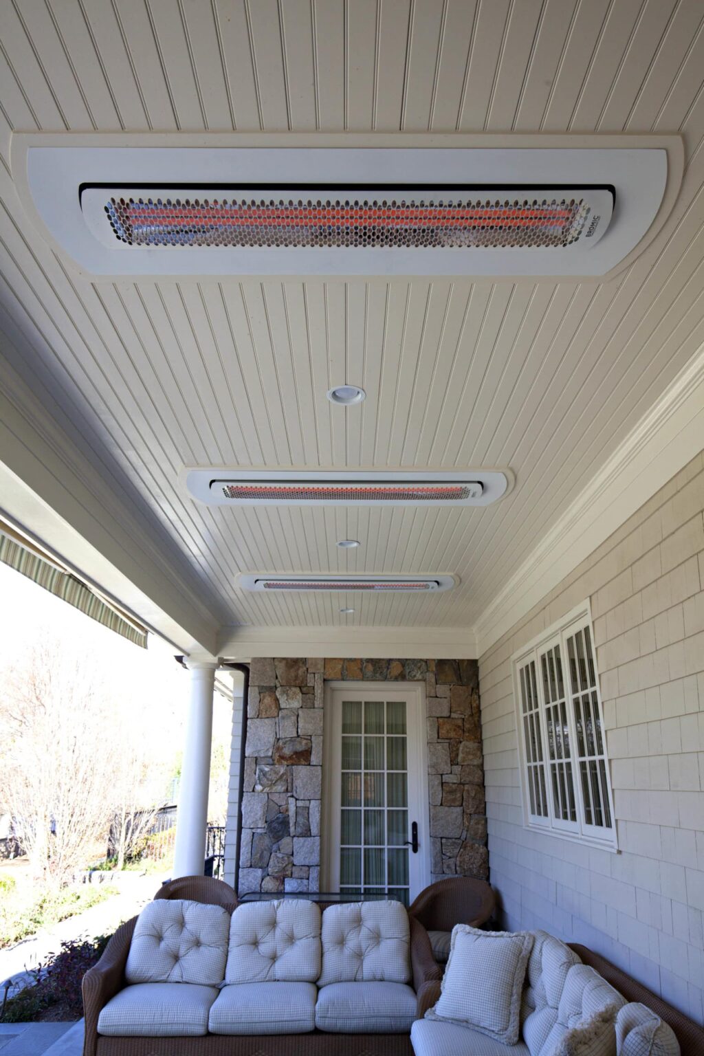 Calefactor eléctrico blanco empotrado en el techo de un porche