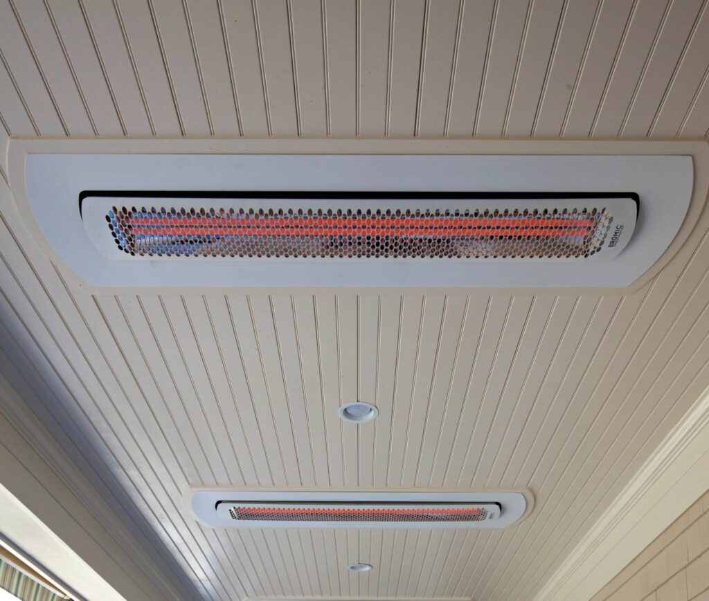 Calefactor eléctrico blanco empotrado en el techo de un porche